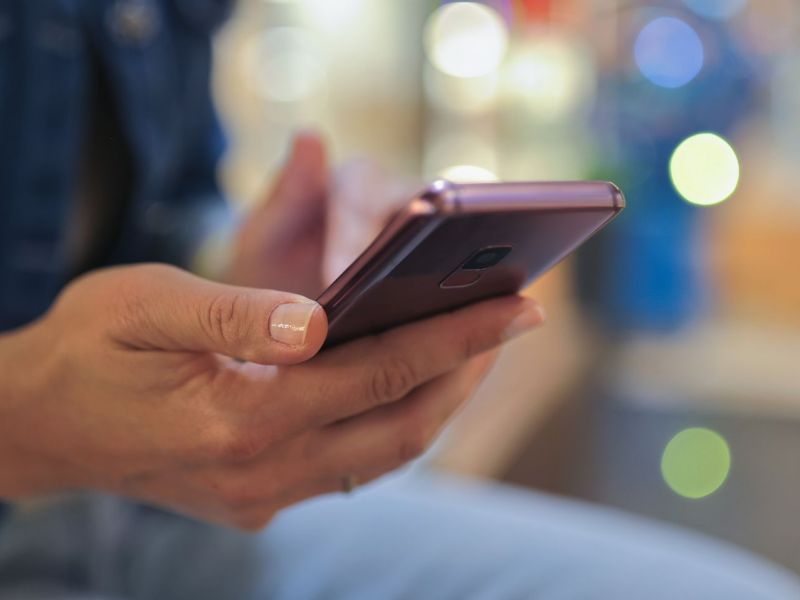 Person hält ein Smartphone in der Hand.