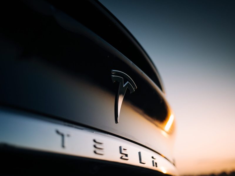 Detailansicht von einem Tesla mit Firmenlogo.