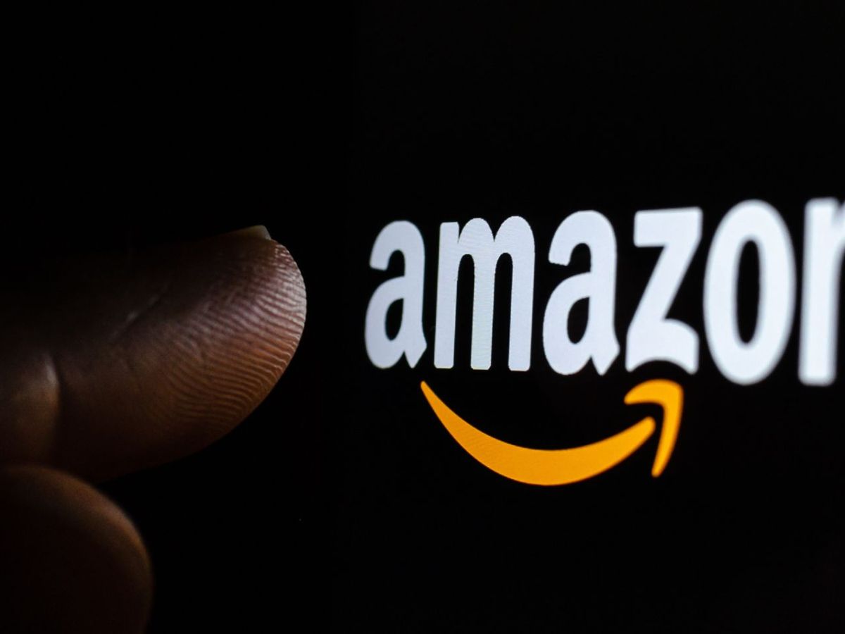 Finger zeigt auf das Amazon-Logo auf einem Bildschirm.