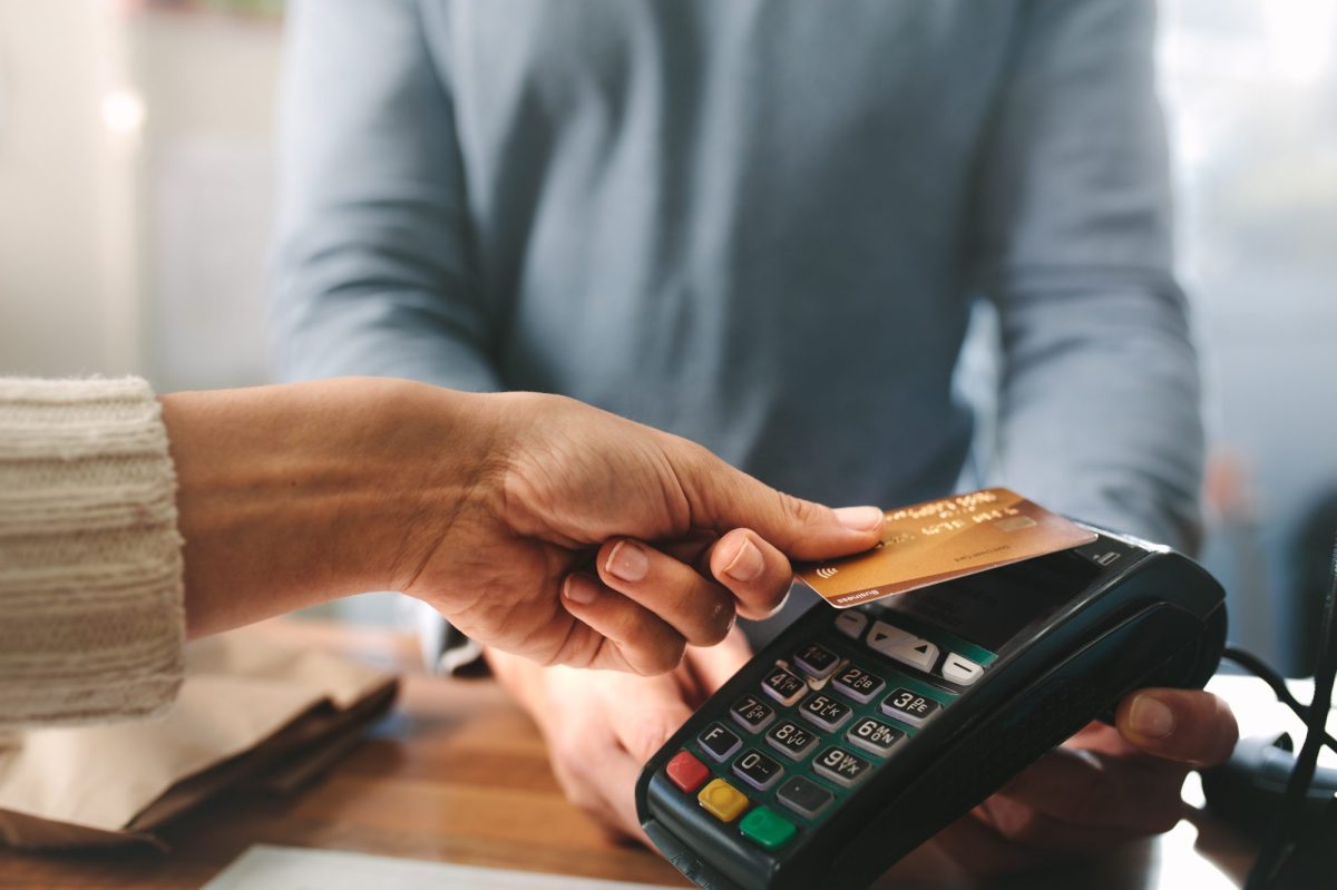 Frau drückt ihre Bankkarte auf ein Überweisungsgerät.