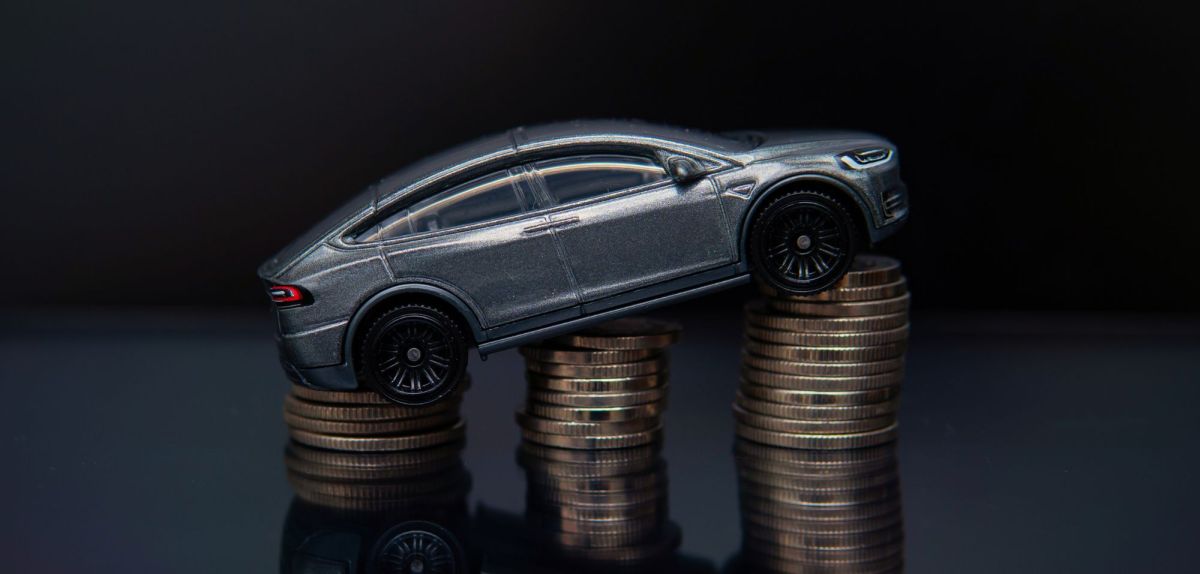 Elektroauto-Modell auf einem Stapel aus Münzen