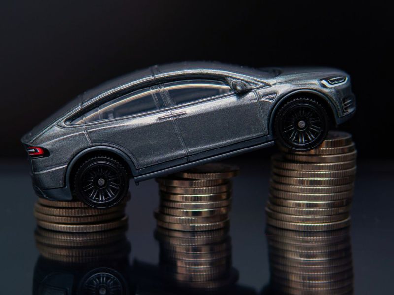 Elektroauto-Modell auf einem Stapel aus Münzen