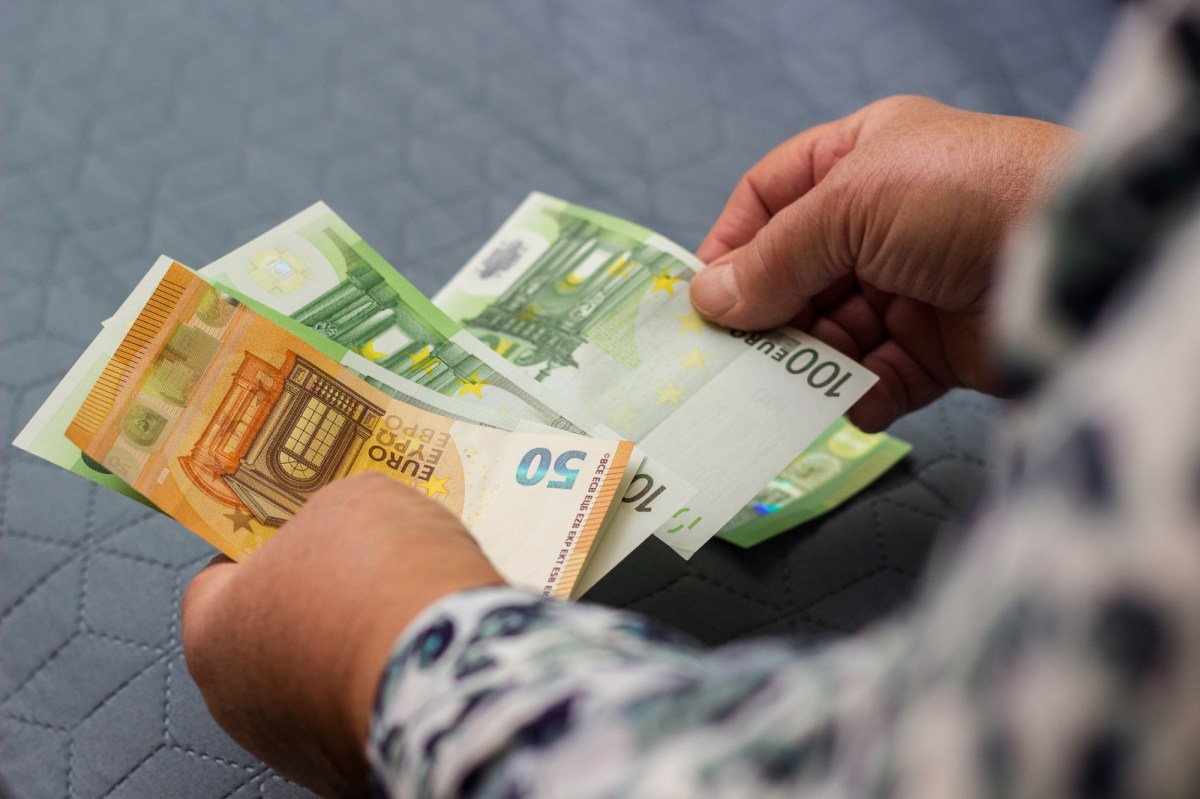 Mann zählt Bargeld in Scheinen