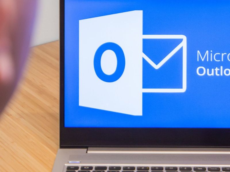 Mann sitzt vor dem Laptop mit Microsoft Outlook.