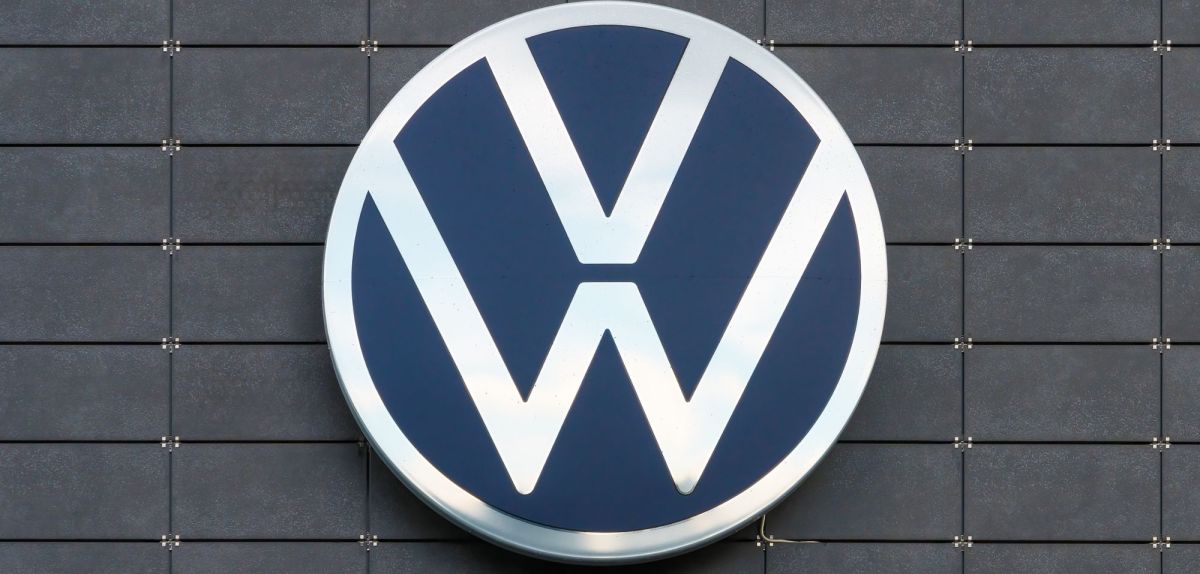 VW-Firmenlogo an einer Gebäudefassade.