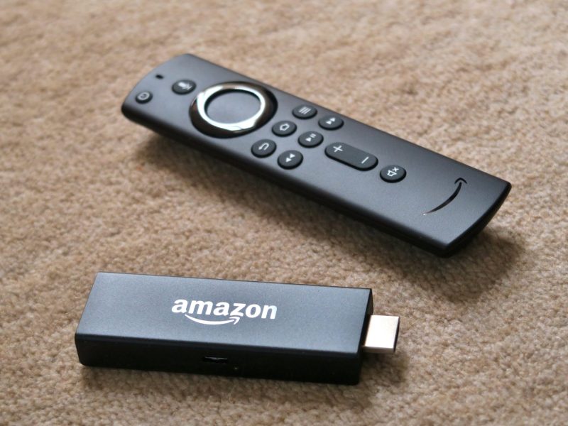 Amazon Fire TV Stick mit Fernbedienung auf dem Boden.