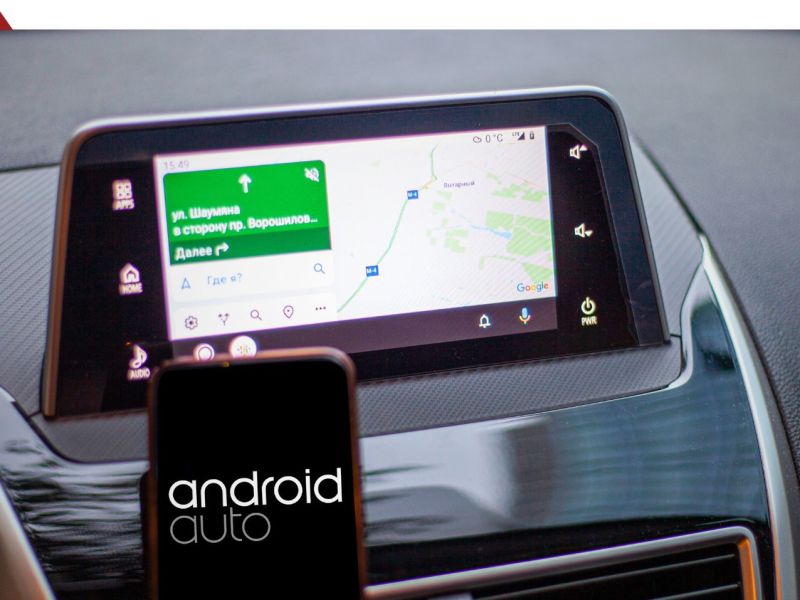 Smartphone vor einem Android Auto-Display