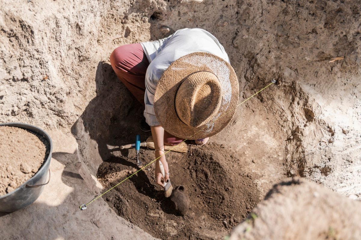 Frau gräbt an einem archäologischen Fund.