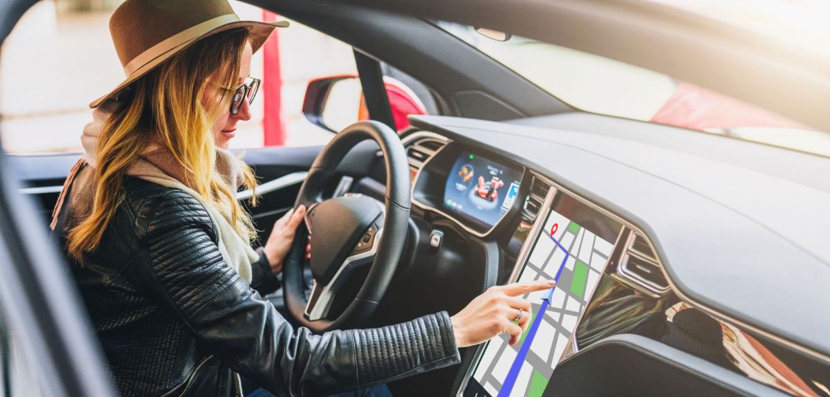 Frau bedient Touchscreen im Auto