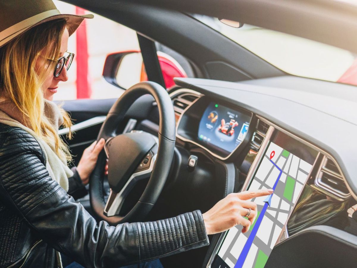 Frau bedient Touchscreen im Auto