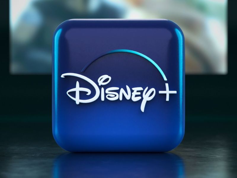 Disney Plus-Logo auf Würfel mit Fernseher im Hintergrund.