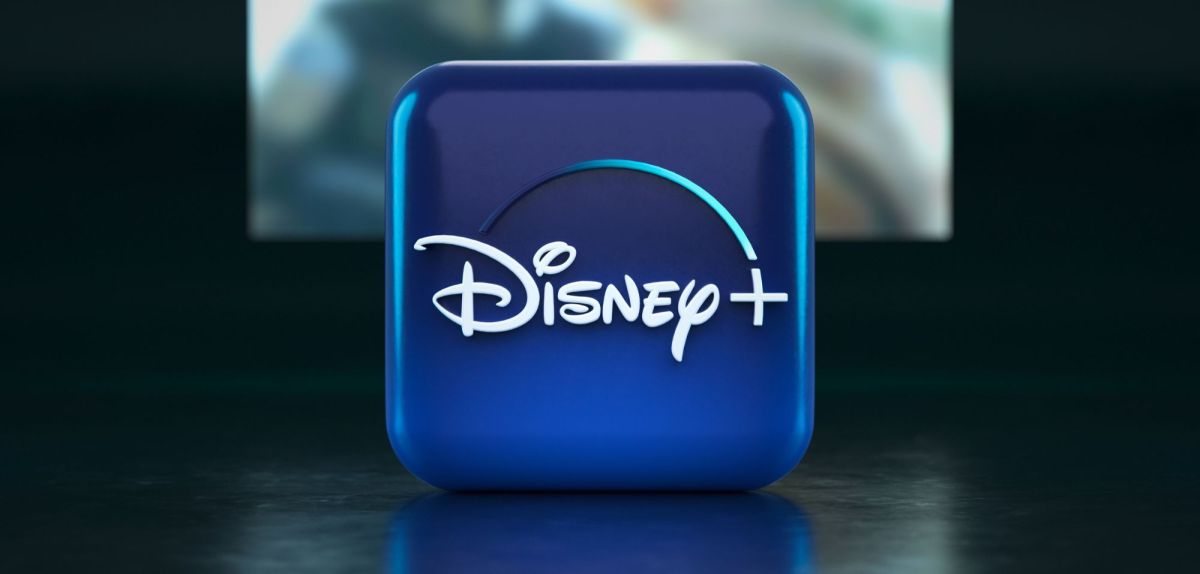 Disney Plus-Logo auf Würfel mit Fernseher im Hintergrund.