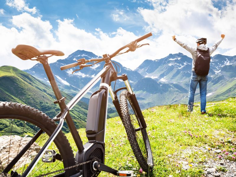 E-Bike auf einer Wiese, mit Mann daneben.