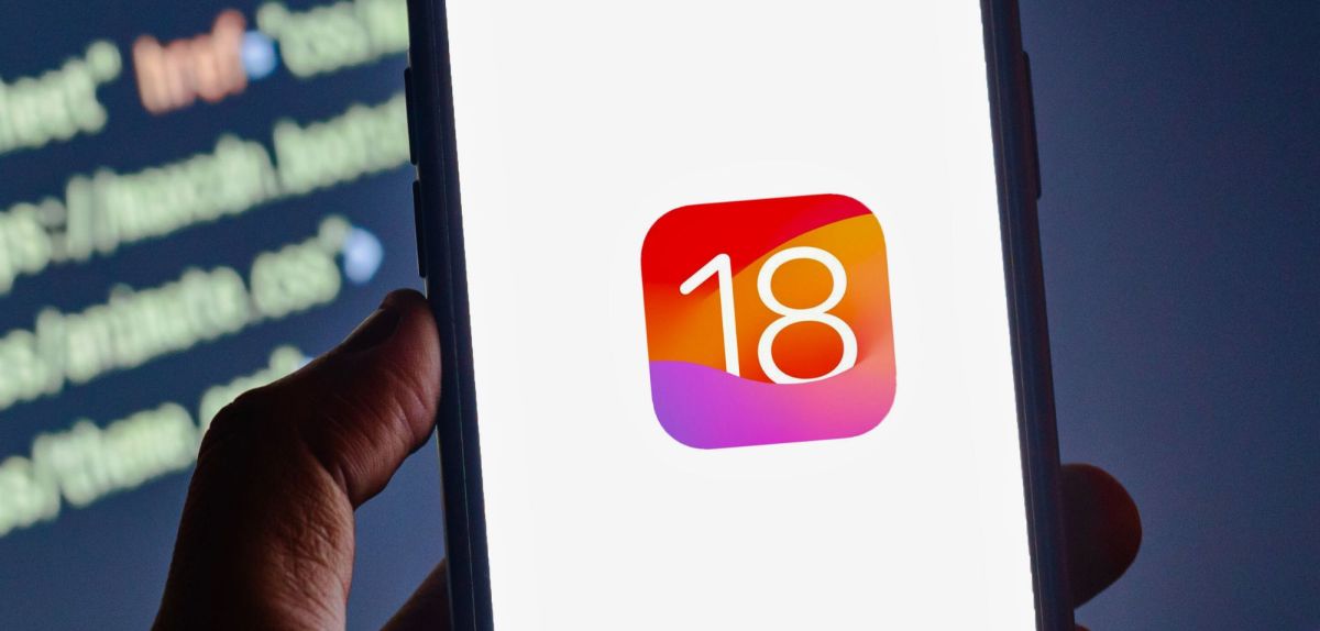 iOS 18-Logo auf iPhone vor Code