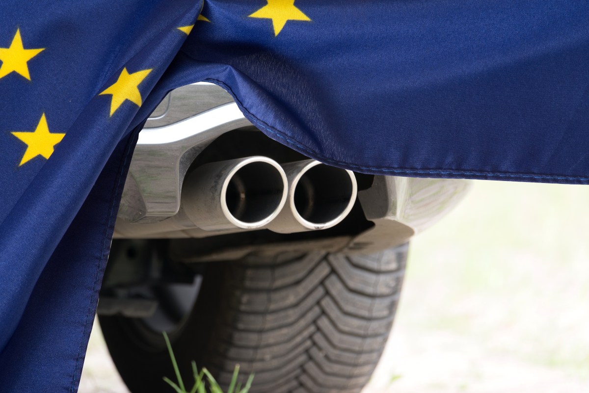 Auto-Auspuff hinter einer EU-Flagge