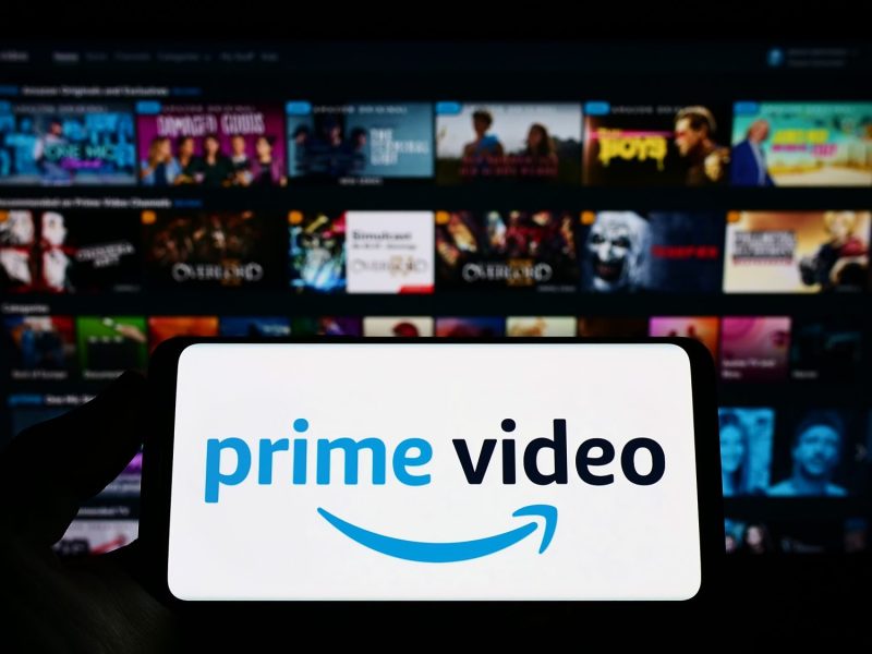 Bildschirm eines Handys zeigt Amazon Prime-Logo vor buntem Hintergrund.