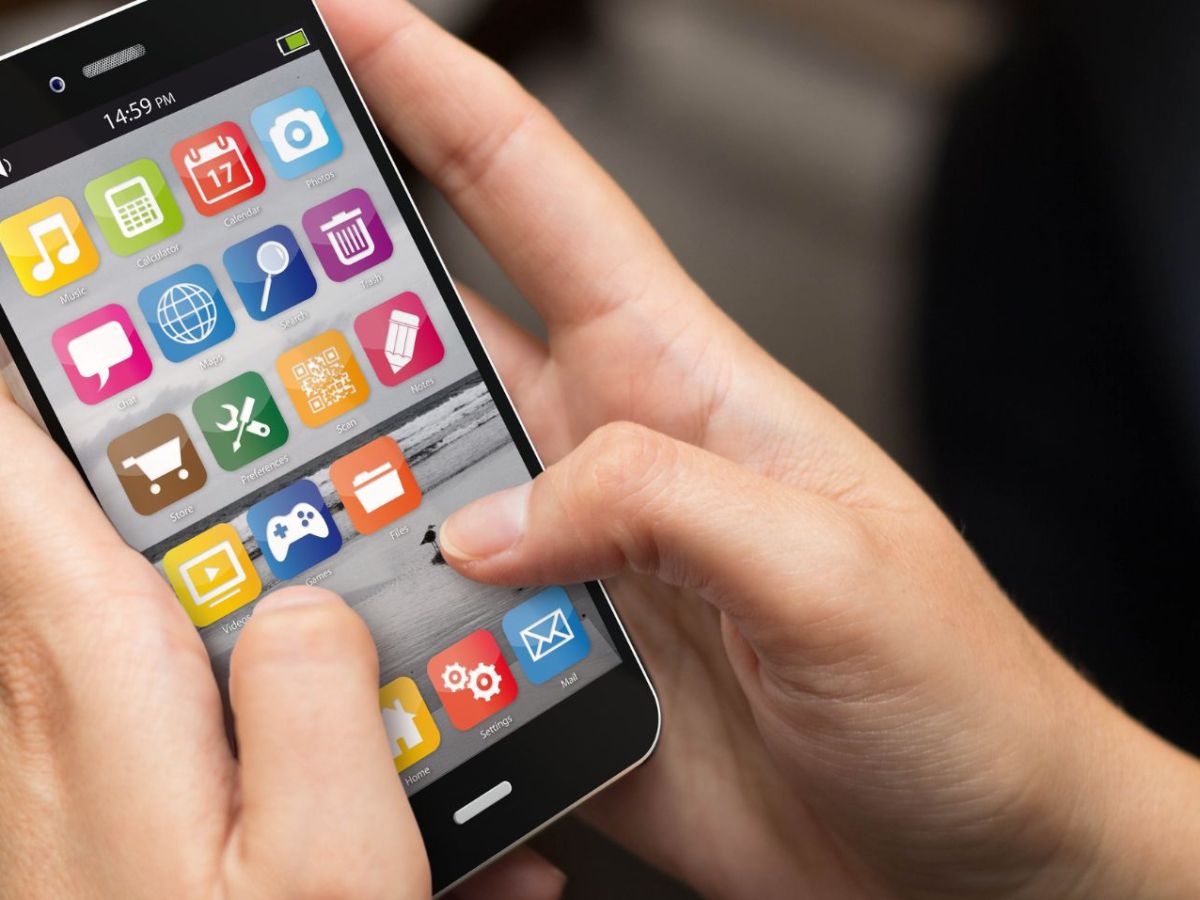 Hände bedienen Smartphone-Bildschirm mit mehreren App-Icons.