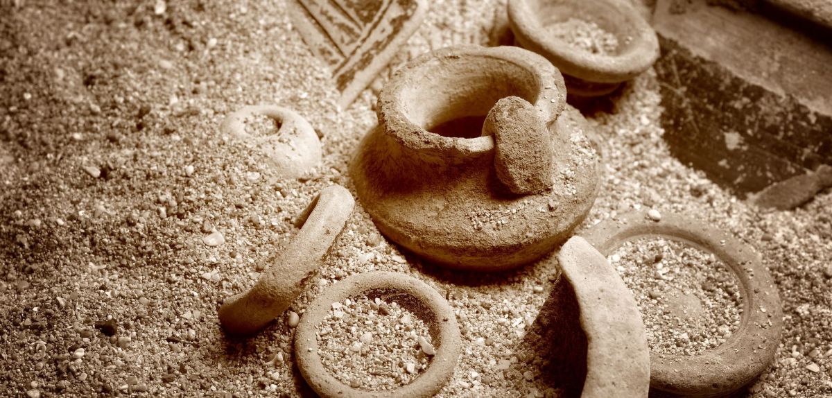 Mehrere Keramikgegenstände im Sand.