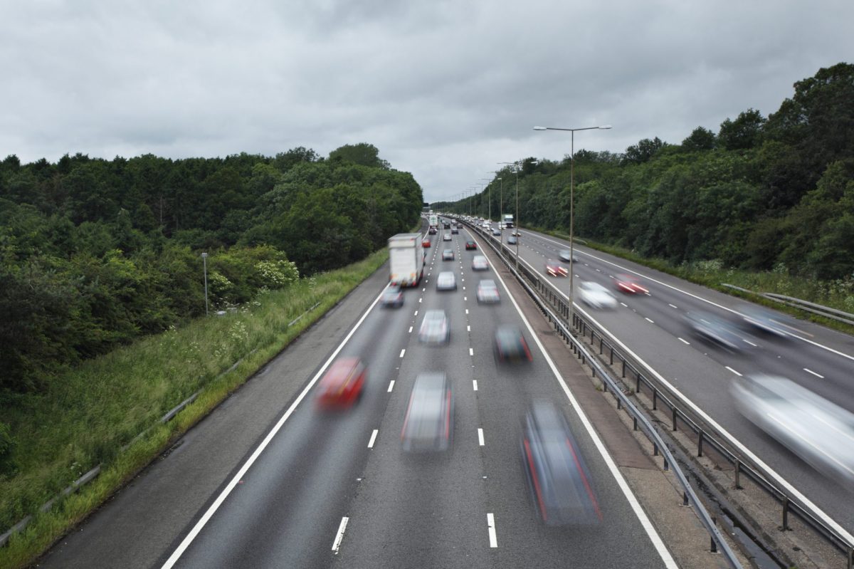 Autos fahren im hohen Tempo über eine Autobahn.