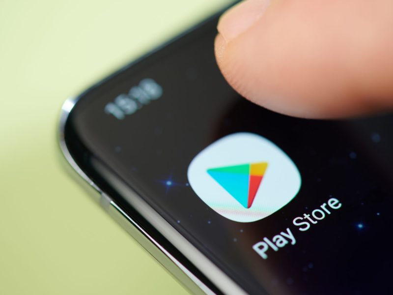 Google Play Store-Android-App wird auf einem Handy-Display angezeigt. Nahaufnahme auf einen Finger, der die App aufruft.