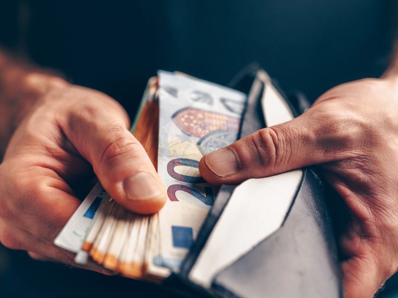Mann prüft das Bargeld im Portemonnaie