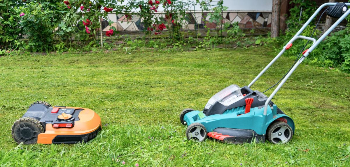 Mähroboter und Rasenmäher stehen sich gegenüber