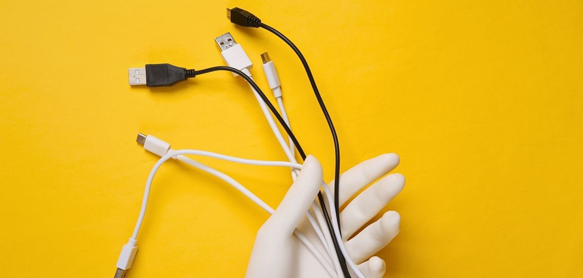 Hand hÃ¤lt Kabel ohne Kabelmanagement.