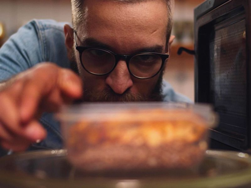 Mann stellt Essen in Mini-Mikrowelle