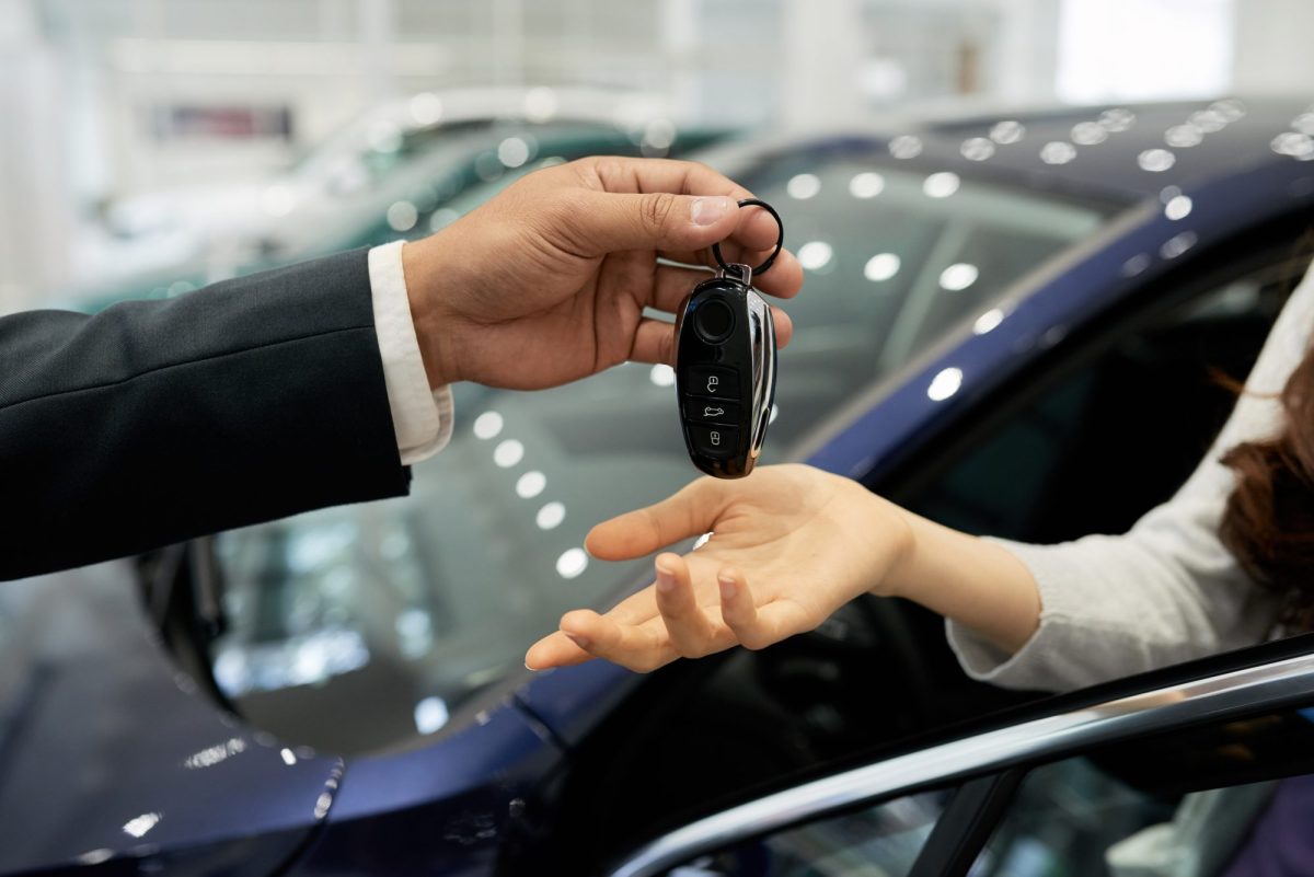 Person Ã¼bergibt einen AutoschlÃ¼ssel an jemanden
