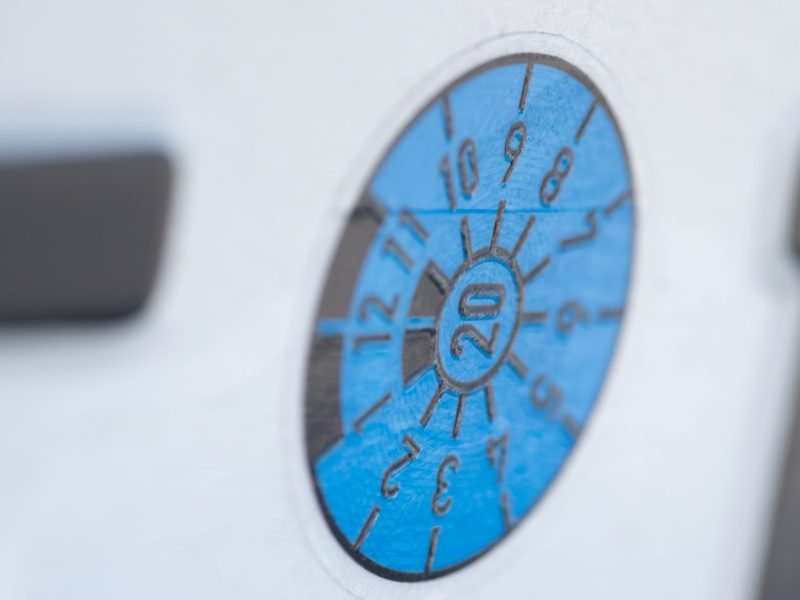 TÜV-Plakette an einem Auto.
