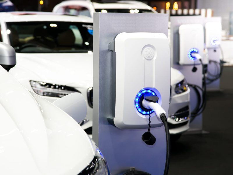 Mehrere Elektroautos laden an Ladesäulen.