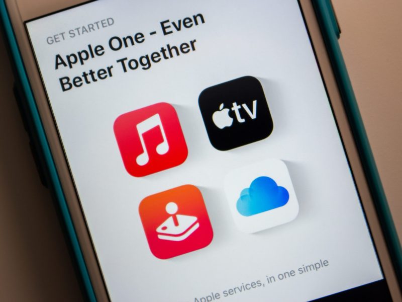 Auf einem Handy-Display werden verschiedene Apple-Dienste angezeigt.