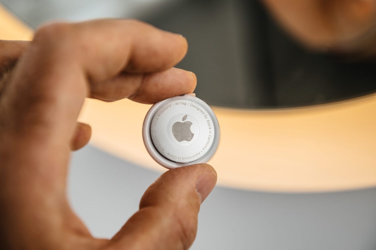 Person hält einen Airtag von Apple in der Hand.