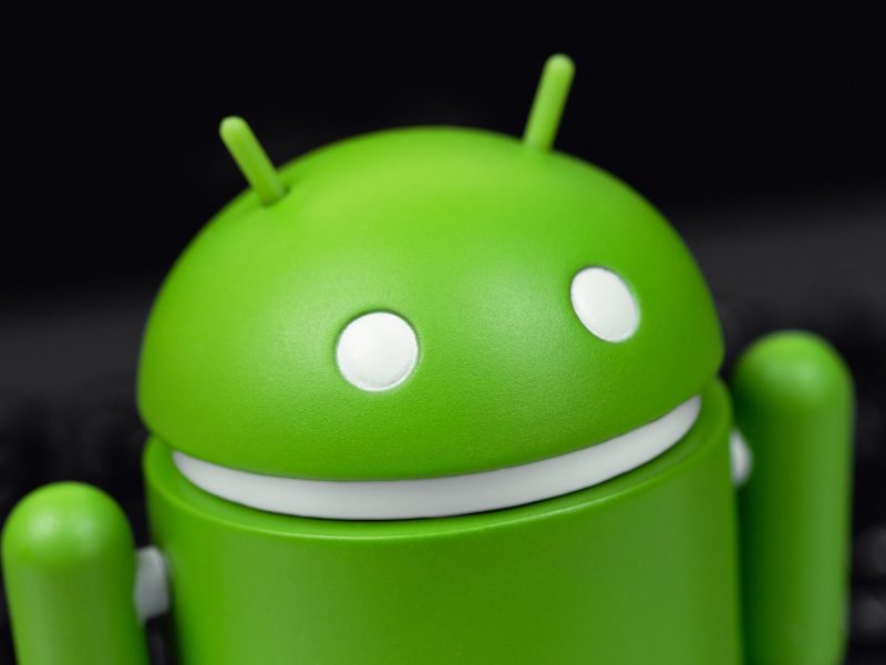 Grünes Android-Maskottchen vor schwarzem Hintergrund.