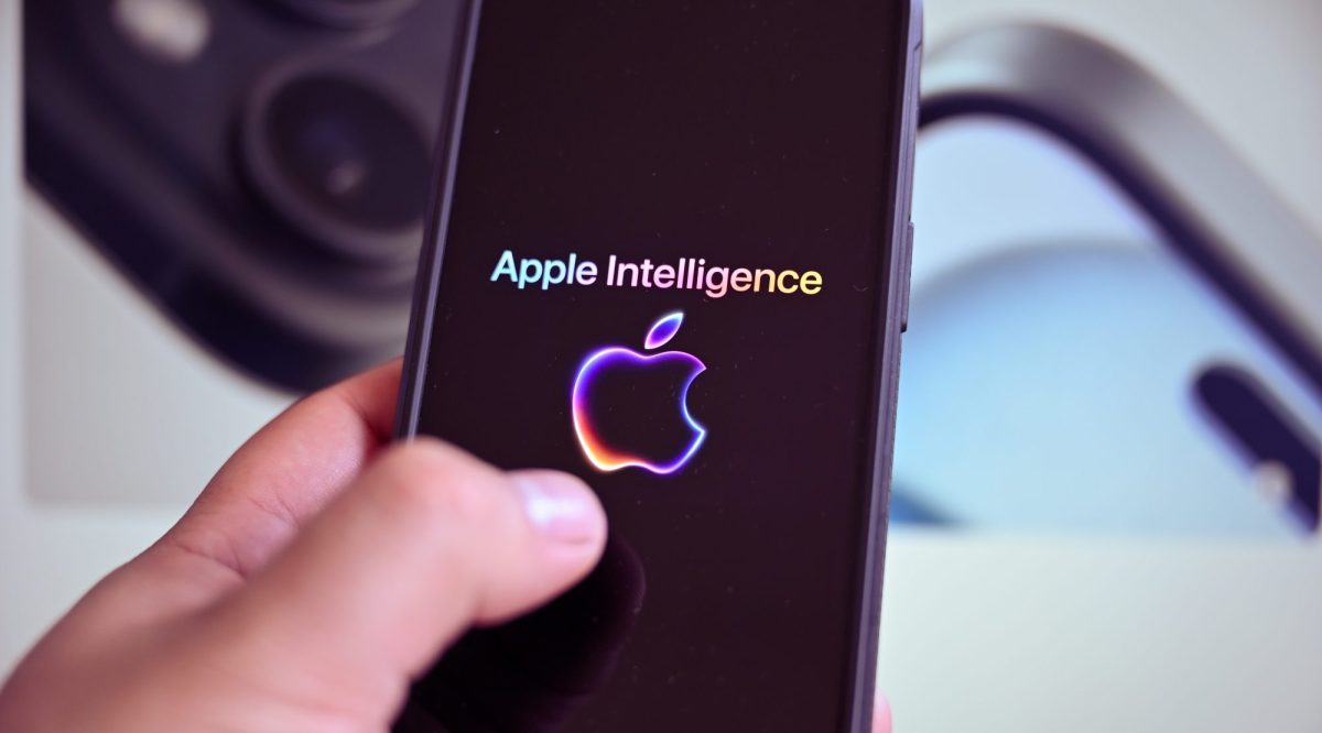 Eine Person hÃ¤lt ein Handy in der Hand. Auf dem Display wird das Logo von Apple Intelligence angezeigt.