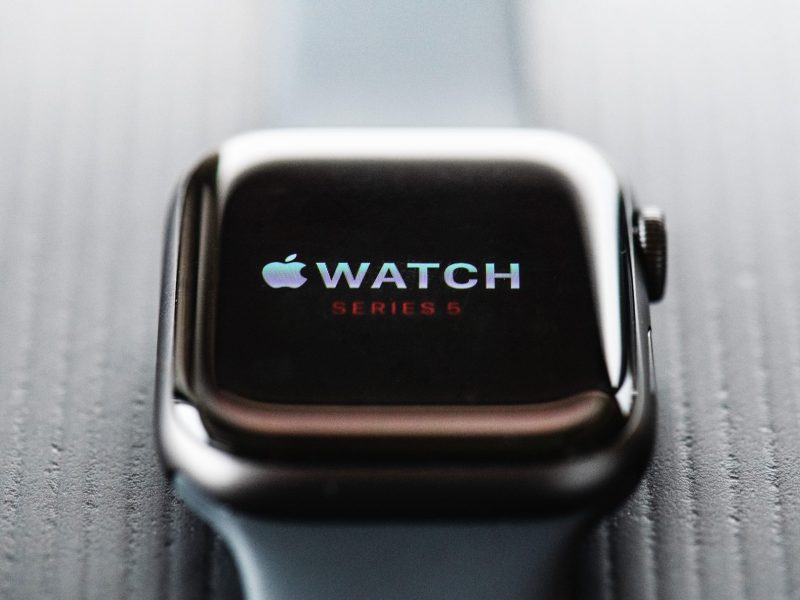 Nahaufnahme auf eine Apple Watch, die auf einem grauen Untergrund liegt.