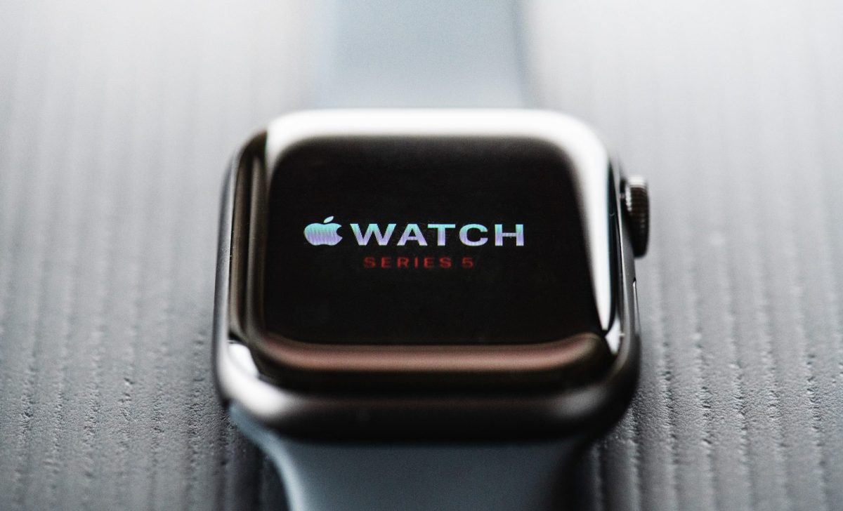 Nahaufnahme auf eine Apple Watch, die auf einem grauen Untergrund liegt.
