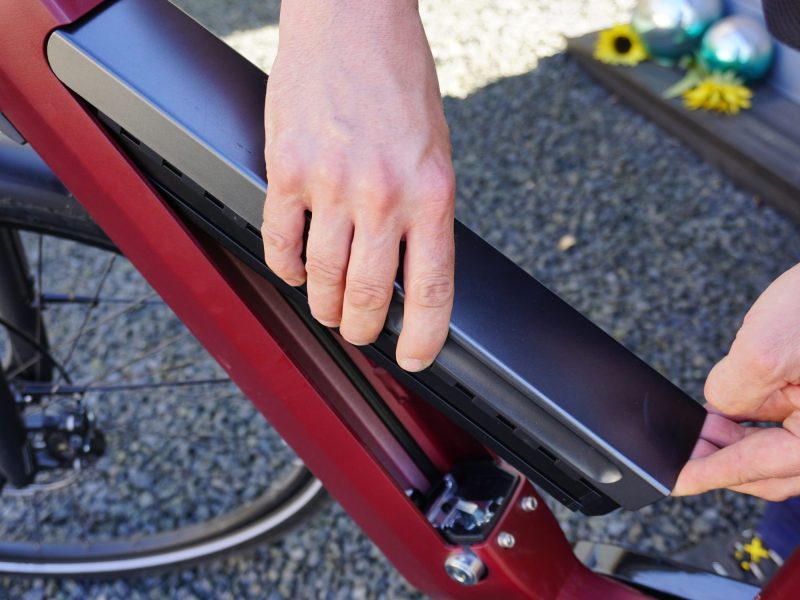 Eine Person setzt ein Akku in ein E-Bike ein.