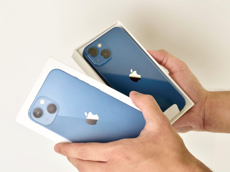 Eine Person hält ein iPhone in einer Verpackung in der Hand.