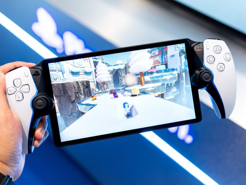 Person hält eine PlayStation Portal in der Hand.