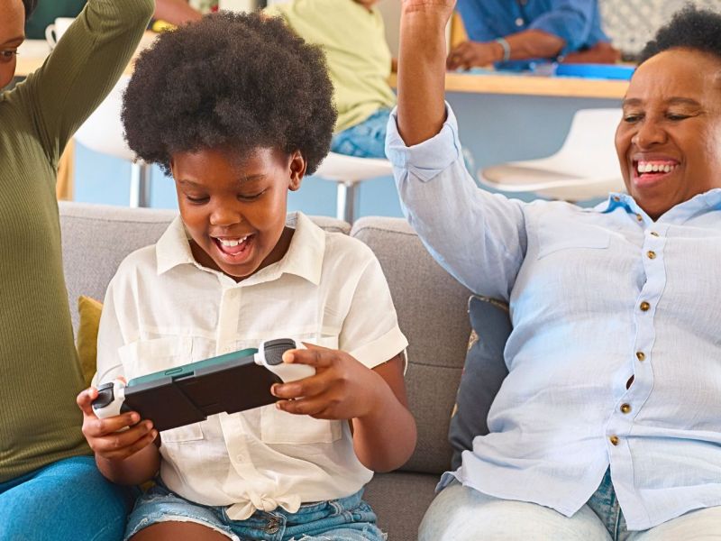 Familie spielt mit Handheld-Konsole.