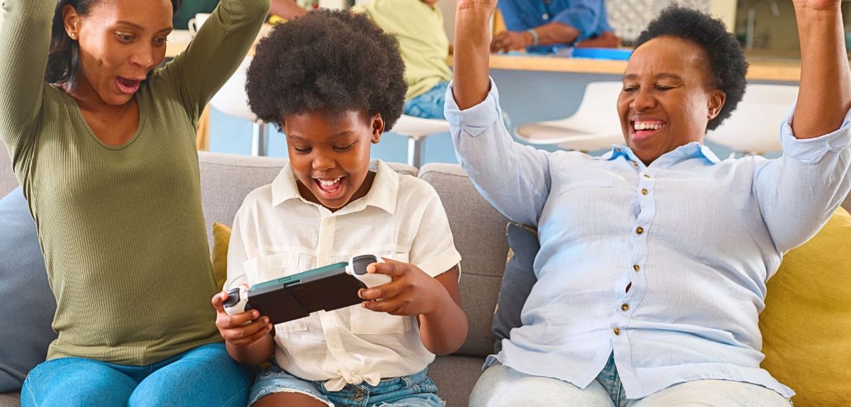 Familie spielt mit Handheld-Konsole.