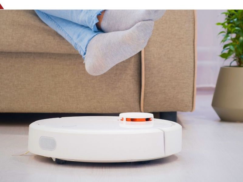 Saugroboter vor einem Sofa