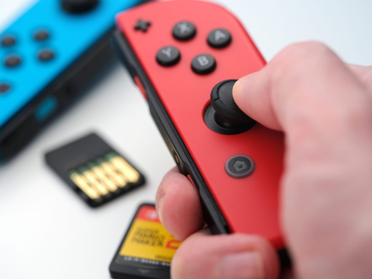 Person hÃ¤lt einen Joy Con in der Hand