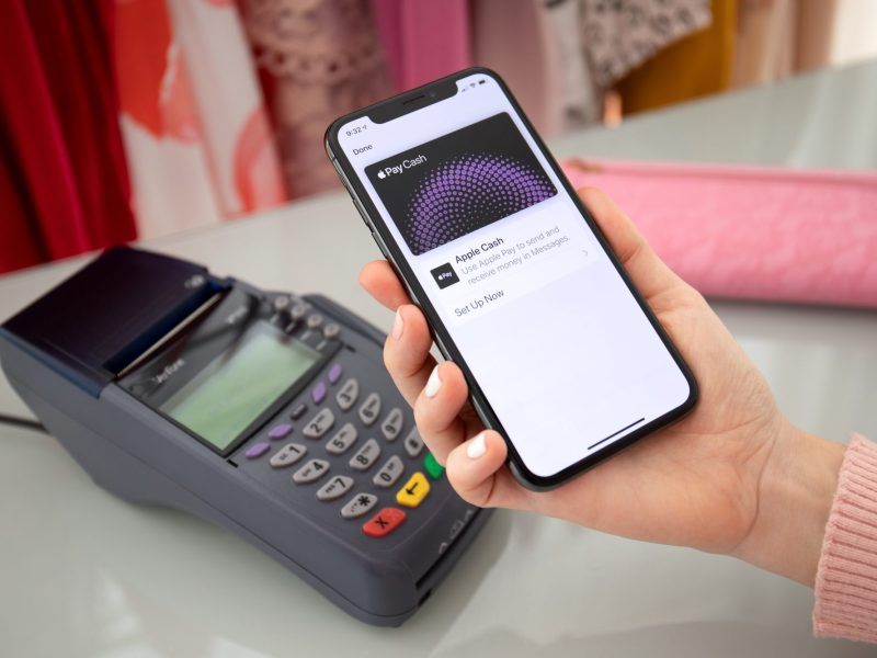 Person bezahlt mit Apple Pay via Smartphone.