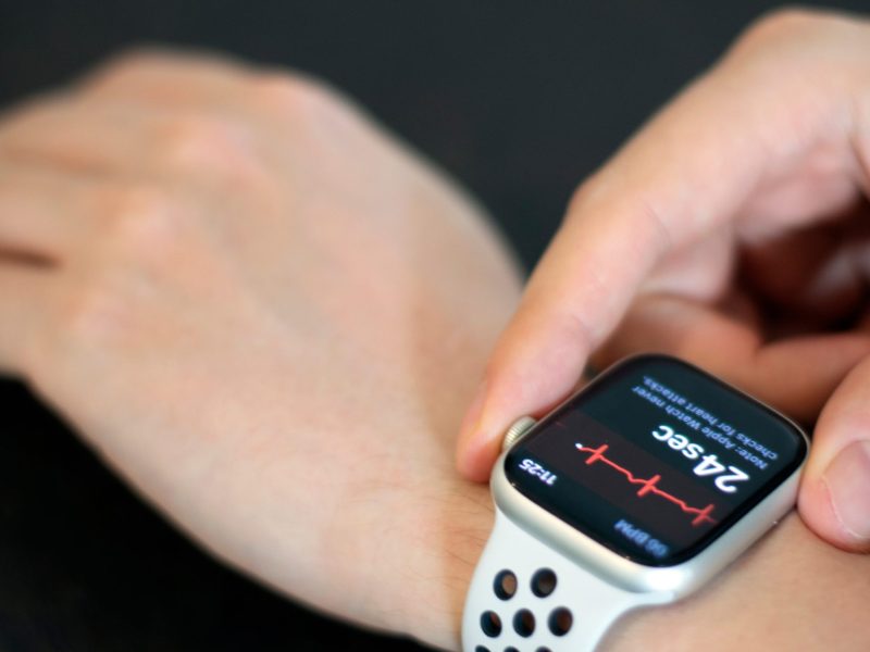 Person trägt eine Apple Watch am Handgelenk. Auf dem Display wird die Herzfrequenz angezeigt.
