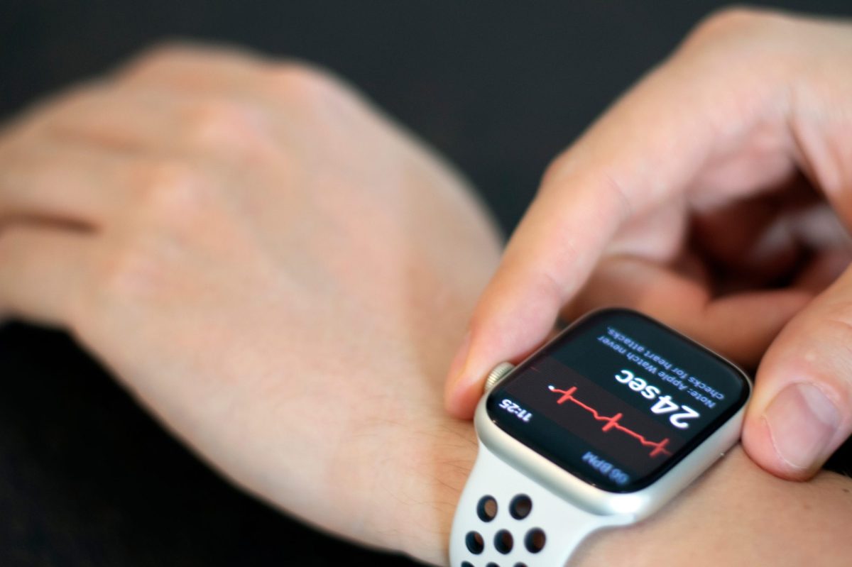 Person trägt eine Apple Watch am Handgelenk. Auf dem Display wird die Herzfrequenz angezeigt.