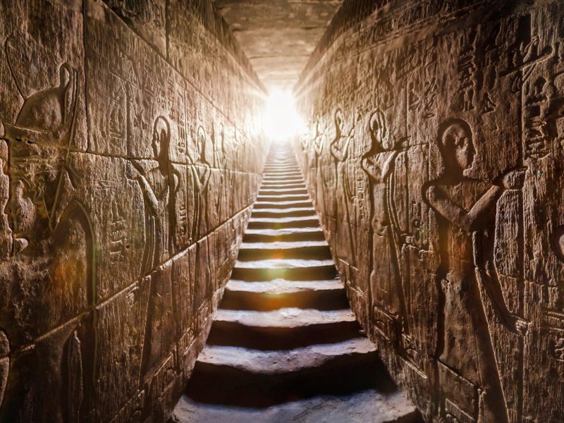 KI-generiertes Bild eines schmalen Ganges mit Treppenstufen und ägyptischen Symbolen an den Wänden.