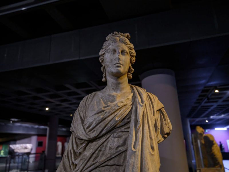 Statue als archäologischer Fund in einem Ausstellungsraum.