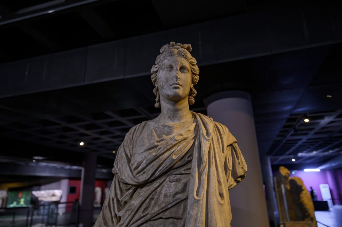 Statue als archäologischer Fund in einem Ausstellungsraum.